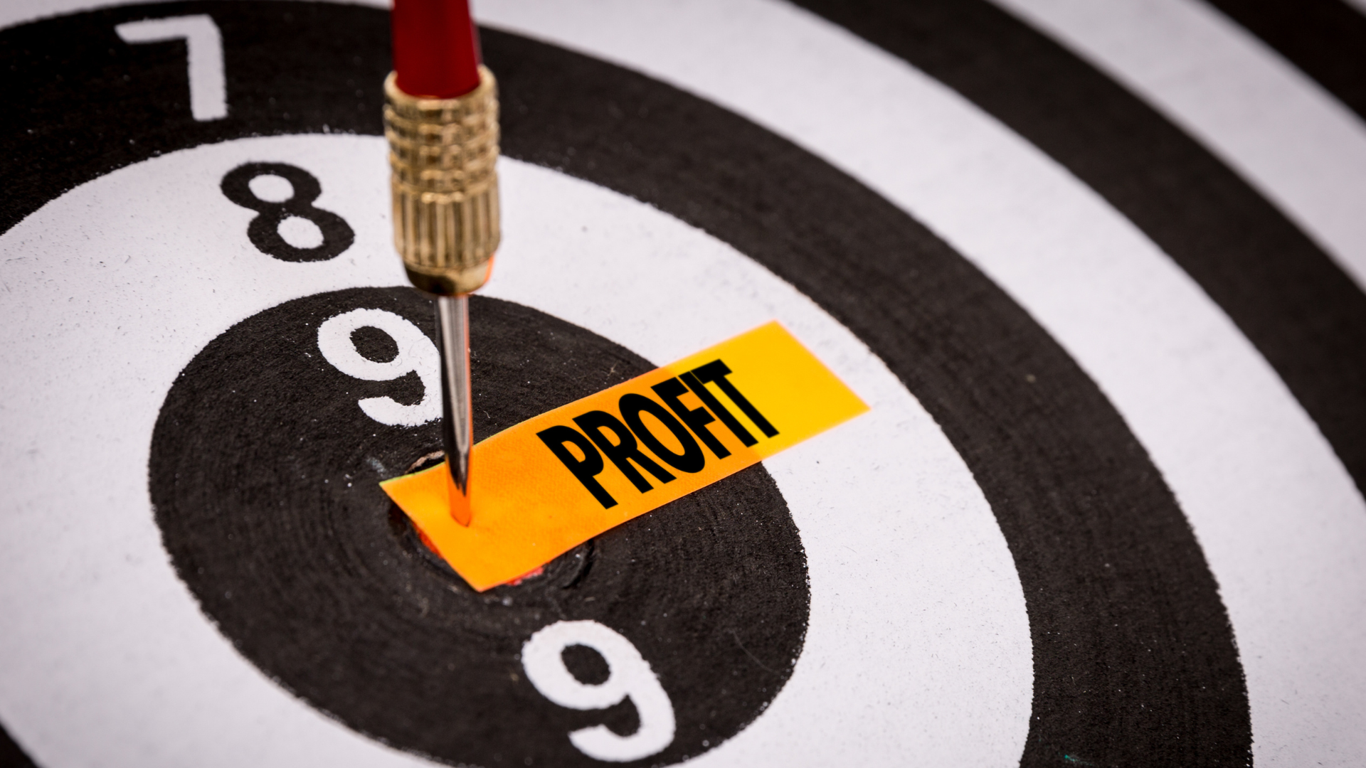 Close-up of a dart hitting the bullseye labeled 'Profit,' symbolizing profit-driven pricing strategies that help businesses achieve optimal financial success.